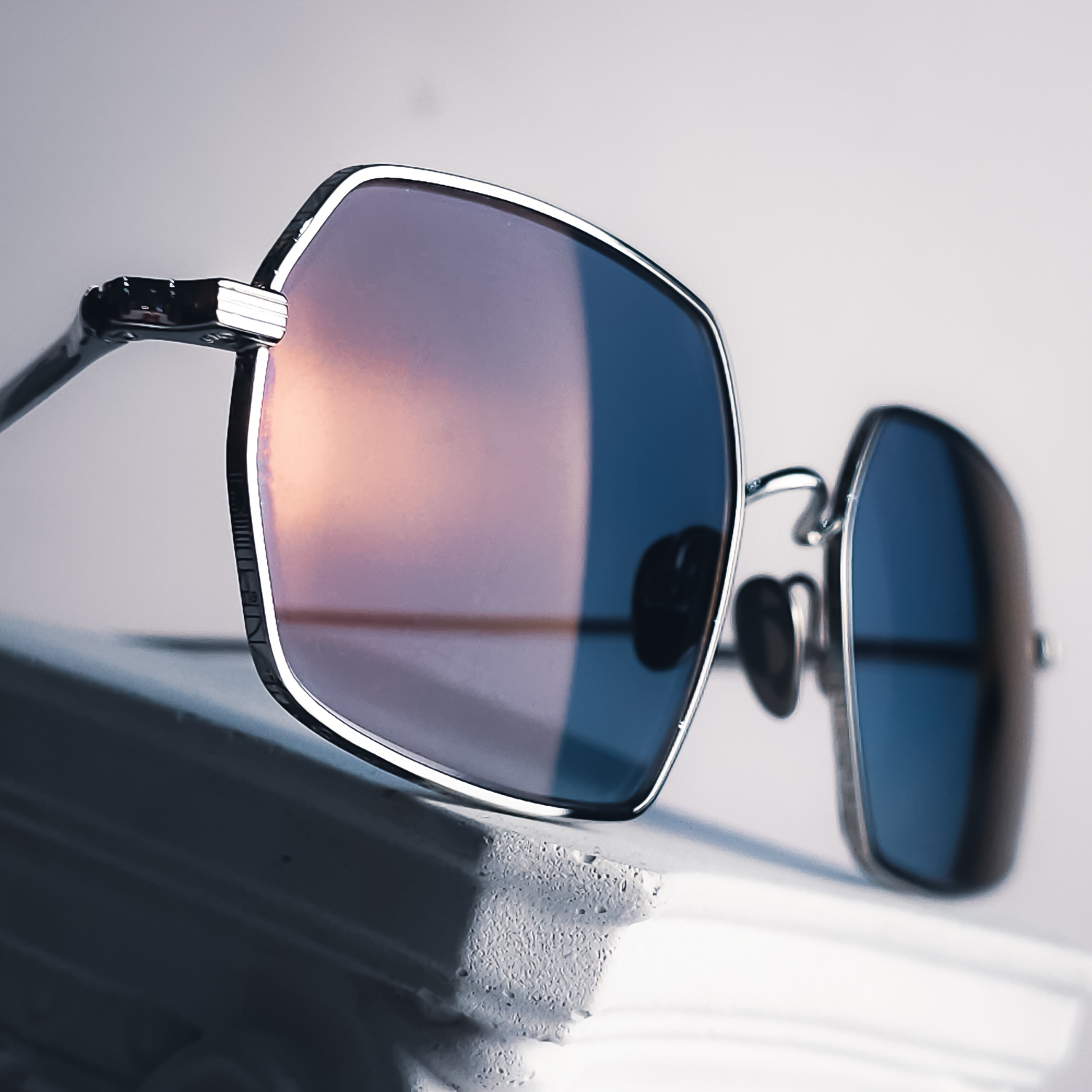Macro detail of an AHLEM Colisée White Gold fitted with a bespoke Lens Art® lens composition featuring a custom petrol gradient, Marma Blue Ocean Dinamica photochromic technology and Glamour coating through luxury reglazing.