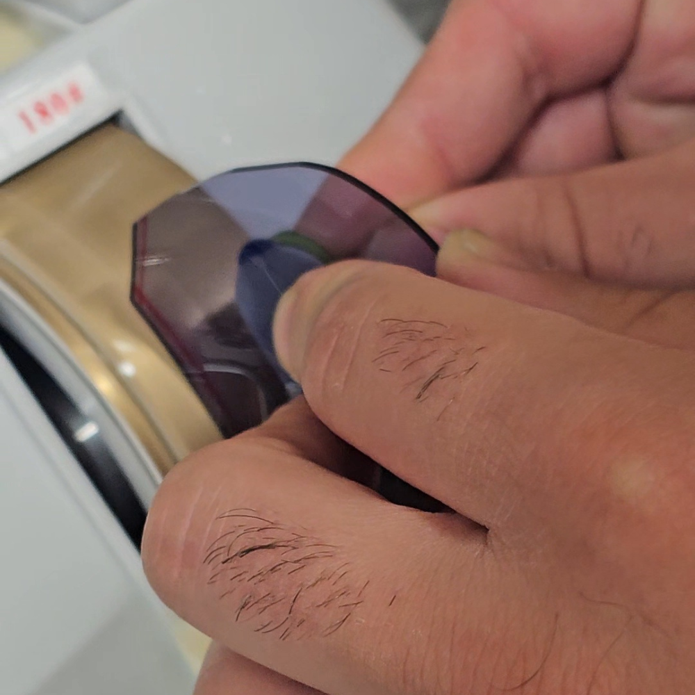 Hand finishing a decorative facet on a bespoke rimless prescription lens