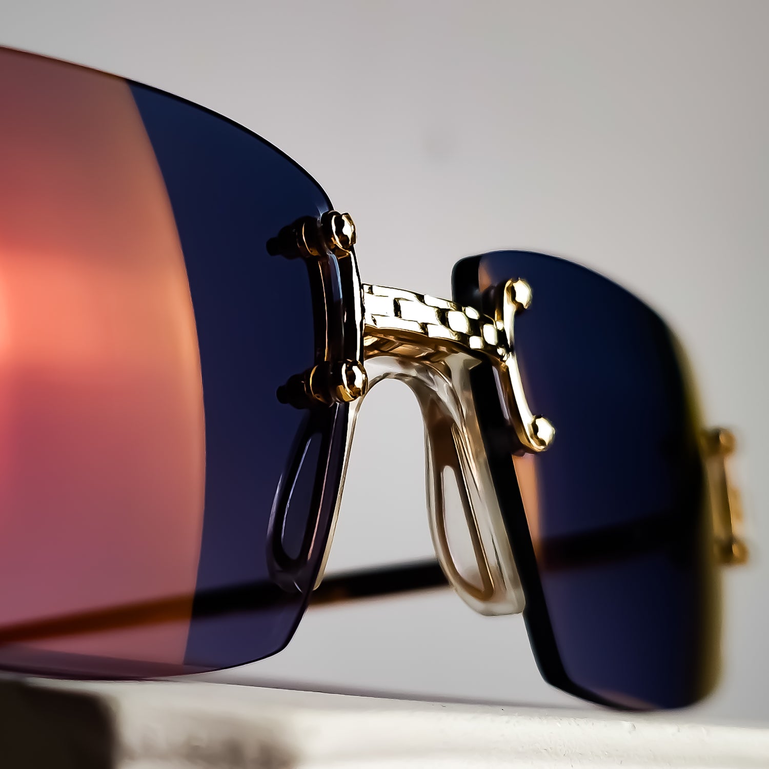 Macro detail of Vintage Tiffany Lunettes rimless eyewear featuring bespoke prescription lenses with a custom Tiffany Blue graduated tint, Transitions® Amethyst photochromic technology, a subtle flash mirror and Marma Glamour coating through the Lens Art® luxury reglazing service.
